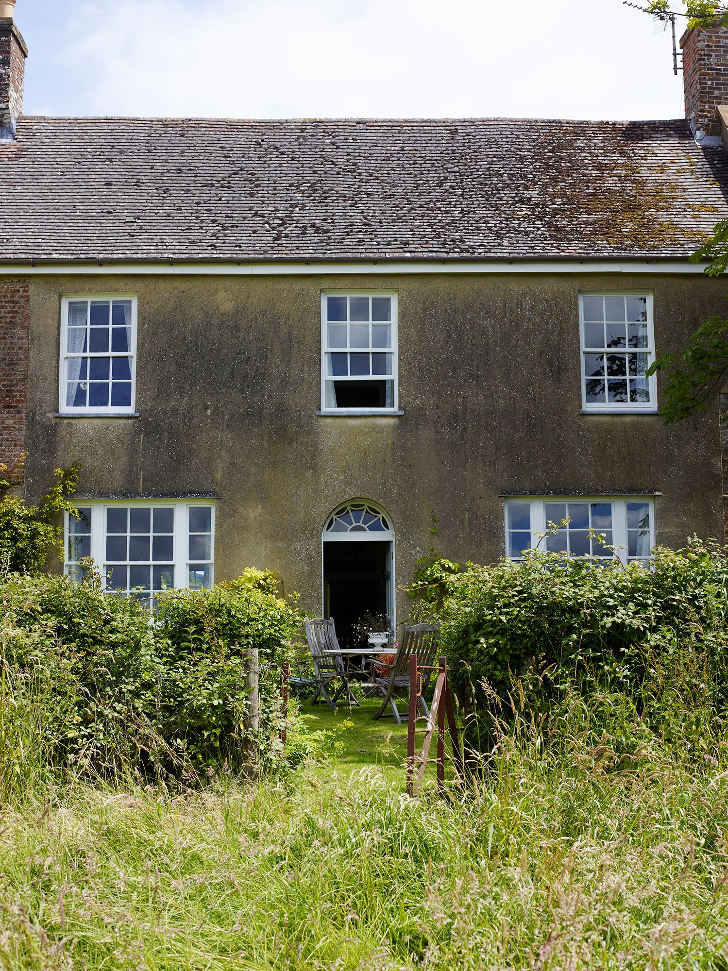 Image may contain Architecture Building Cottage House Housing Chair Furniture Plant and Window