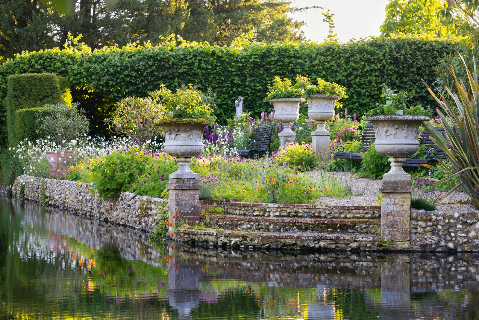 Image may contain Garden Nature Outdoors Pond Water Grass Park Plant Bench Furniture Fence Hedge and Person