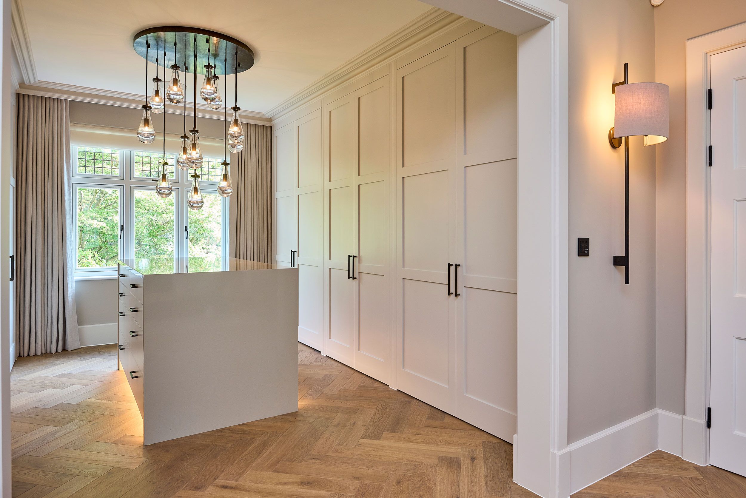 Image may contain: Indoors, Interior Design, Corner, Chandelier, Lamp, Floor, Furniture, Architecture, Building, and Foyer