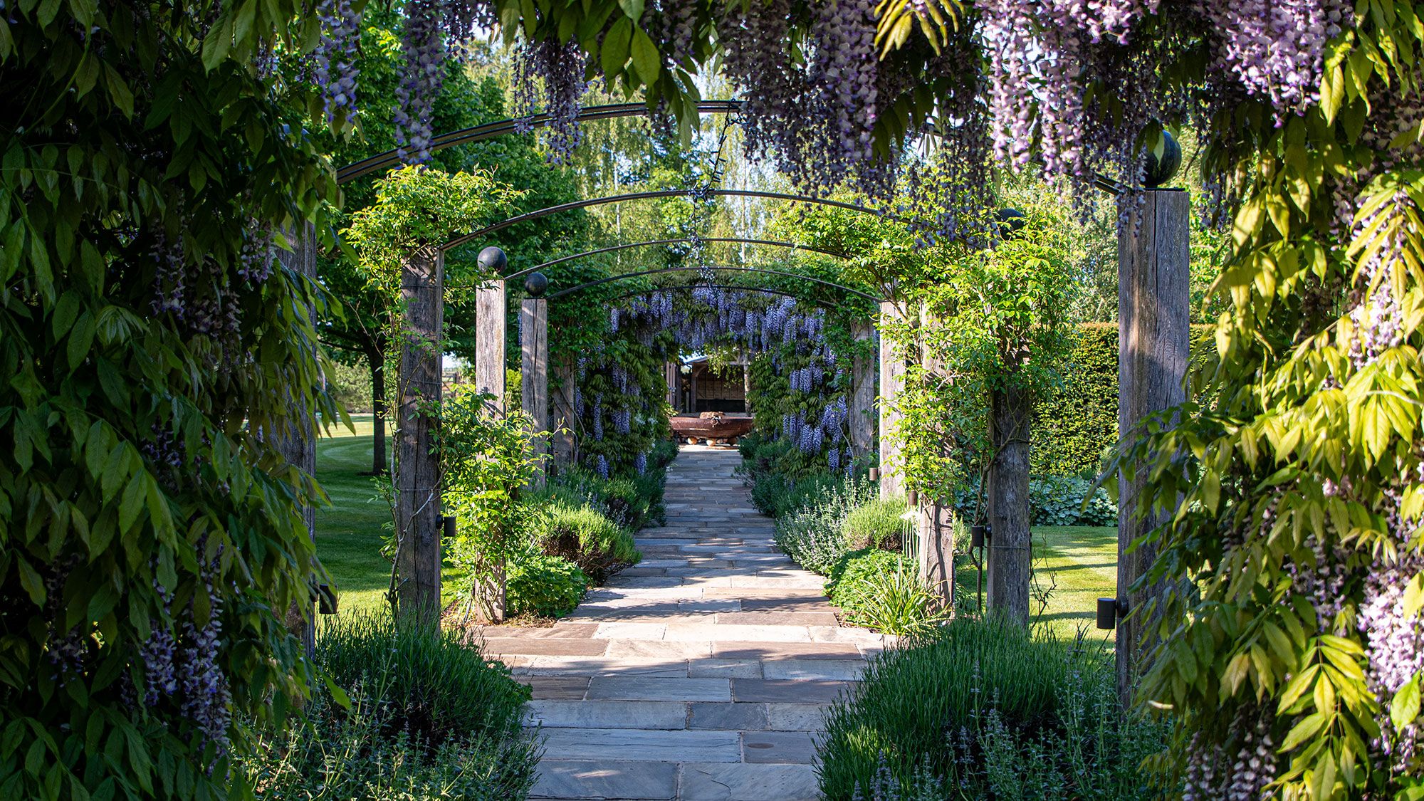 Image may contain: Garden, Nature, Outdoors, Arbour, Architecture, Building, House, Housing, Porch, Patio, Backyard, and Yard