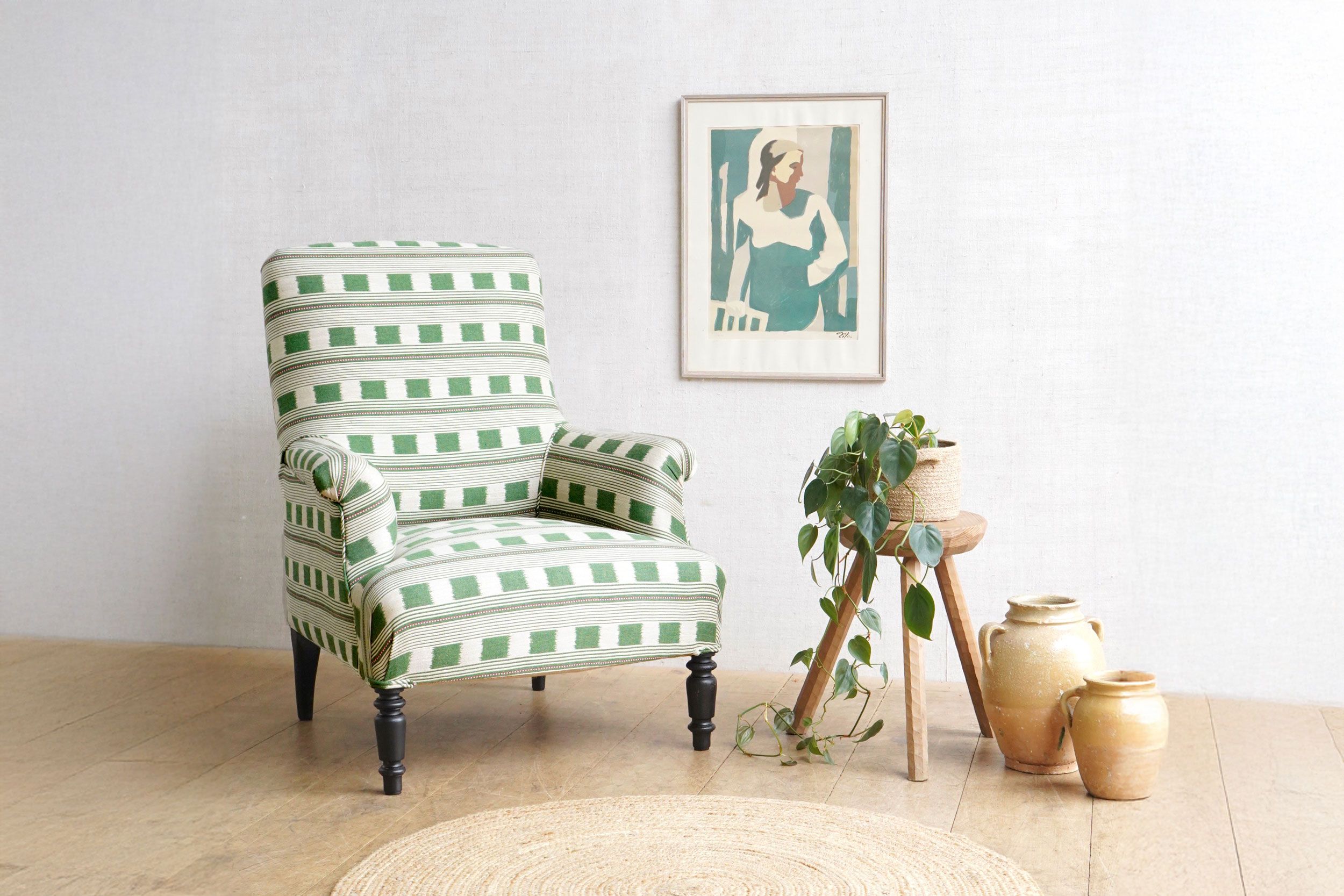 Image may contain: Furniture, Chair, Art, Painting, Home Decor, Rug, Plant, Adult, Person, and Armchair