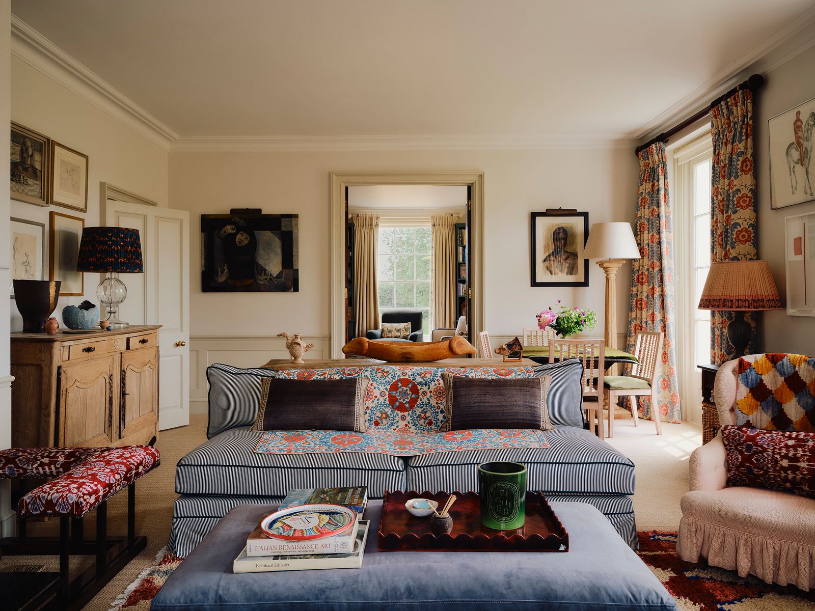 Image may contain Home Decor Book Publication Lamp Cushion Art Painting Cup Couch Furniture Chair and Rug