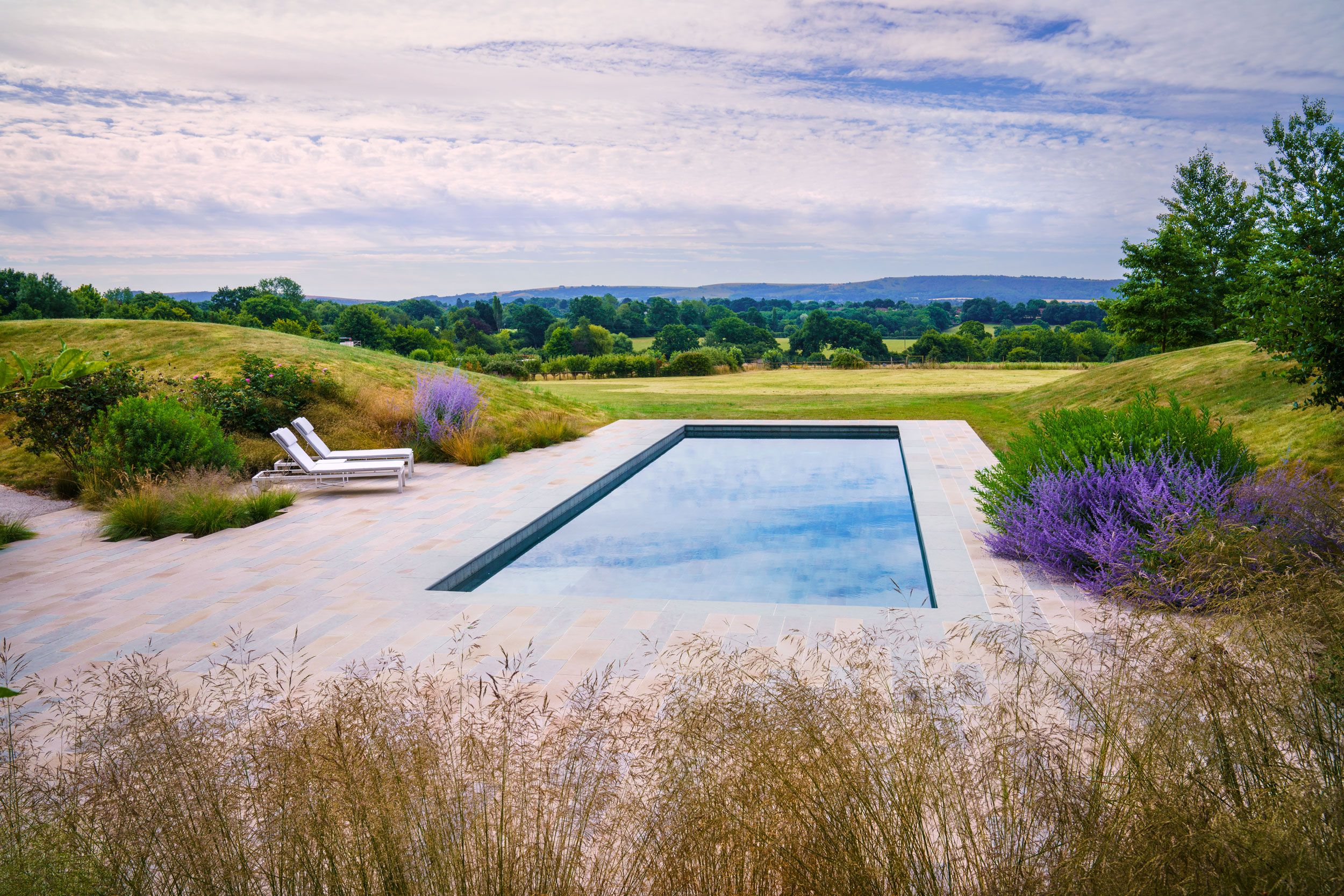 Image may contain: Pool, Water, Swimming Pool, Outdoors, Chair, Furniture, Nature, Scenery, Aerial View, Grass, and Plant