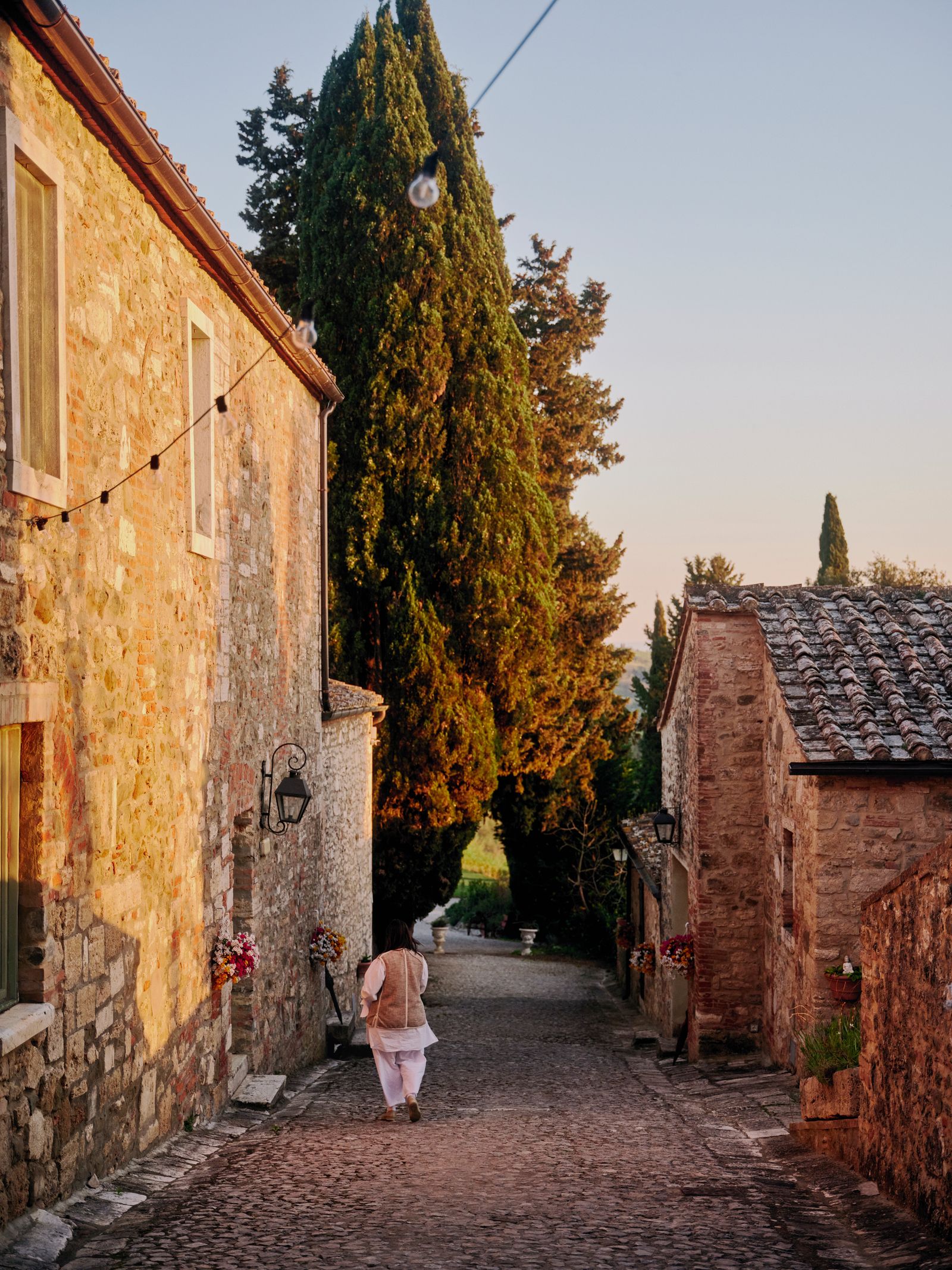 Image may contain City Road Street Urban Alley Path Lamp Person Plant Tree Neighborhood Walking and Architecture