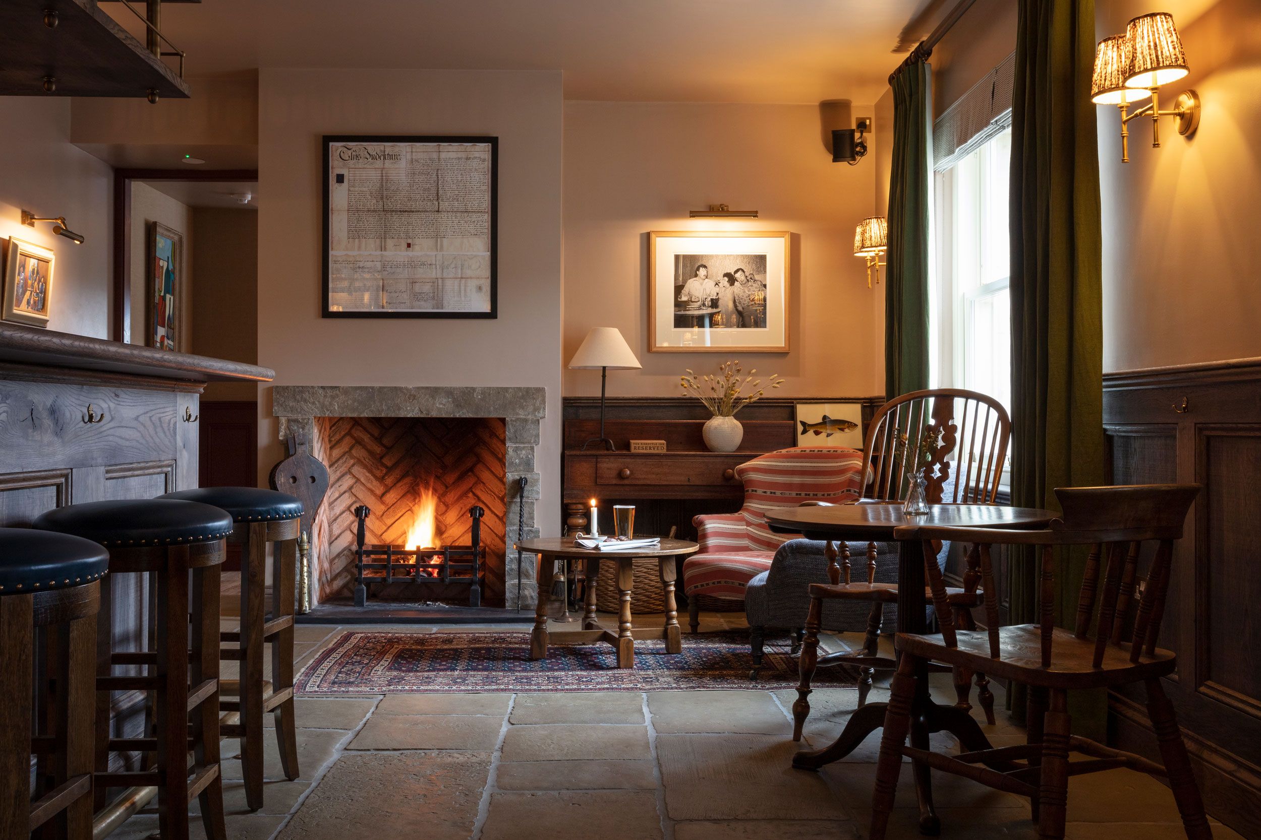 Image may contain: Fireplace, Indoors, Lamp, Chair, Furniture, Interior Design, Art, Painting, Dining Table, Table, and Cup