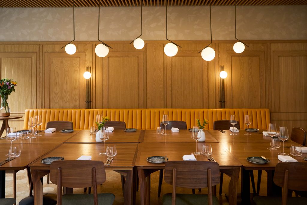 Image may contain Indoors Interior Design Furniture Table Tabletop Dining Table Chair Desk Lamp Plant and Plate