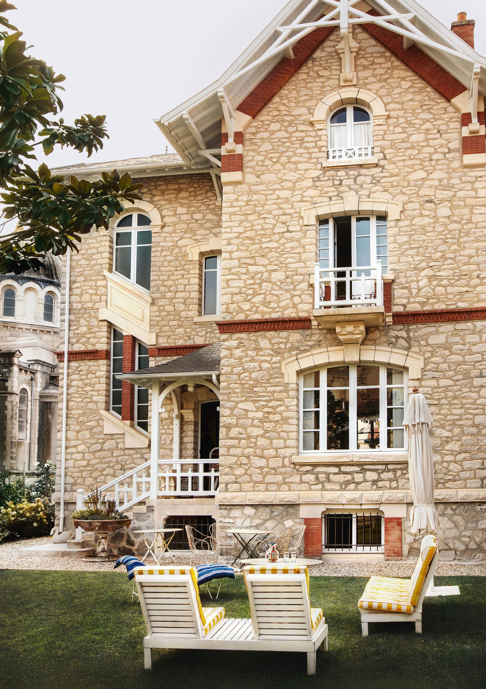 Image may contain Chair Furniture Desk Table City Window Grass Plant Person Architecture Building and Housing