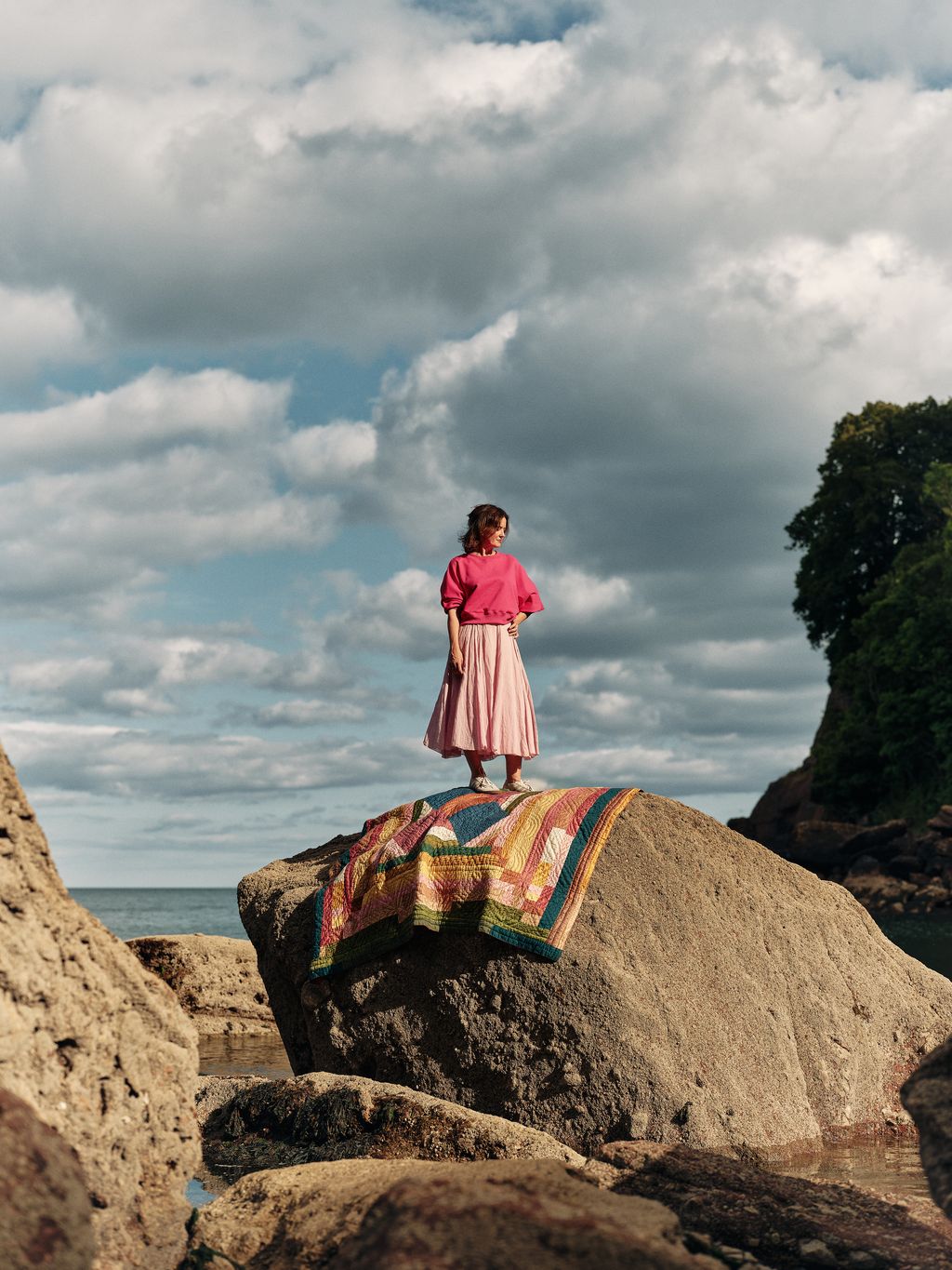 Image may contain Rock Photography Clothing Skirt Face Head Person Portrait Cloud Nature Outdoors Sky and Child