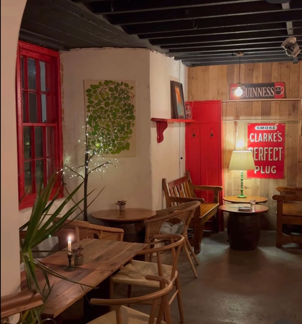 Image may contain Lamp Indoors Interior Design Chair Furniture Cafe Restaurant Plant Desk Table Candle and Wood