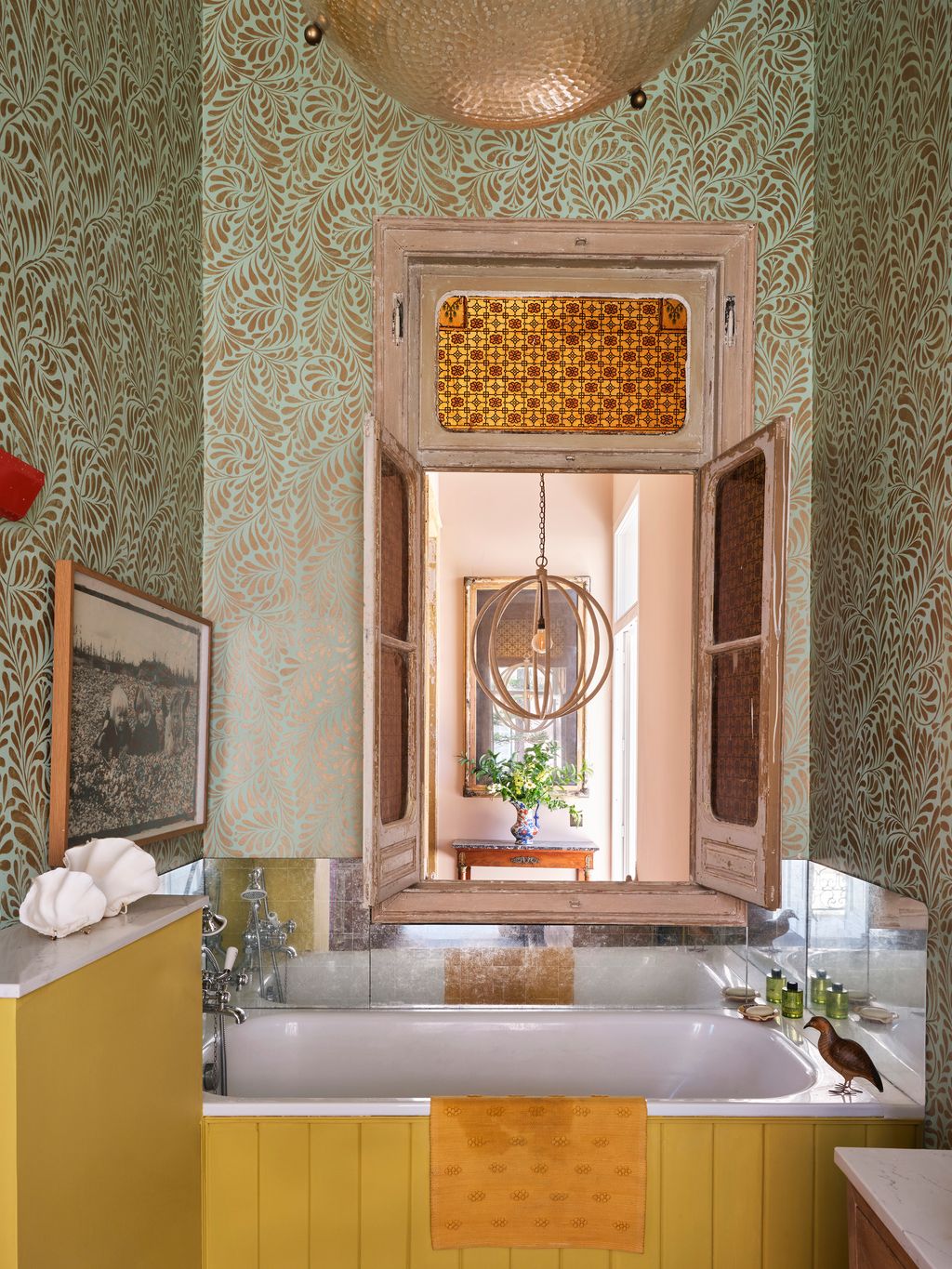 Image may contain Indoors Interior Design Bathing Plant Art Painting Tub Sink Sink Faucet Bathtub Person and Desk