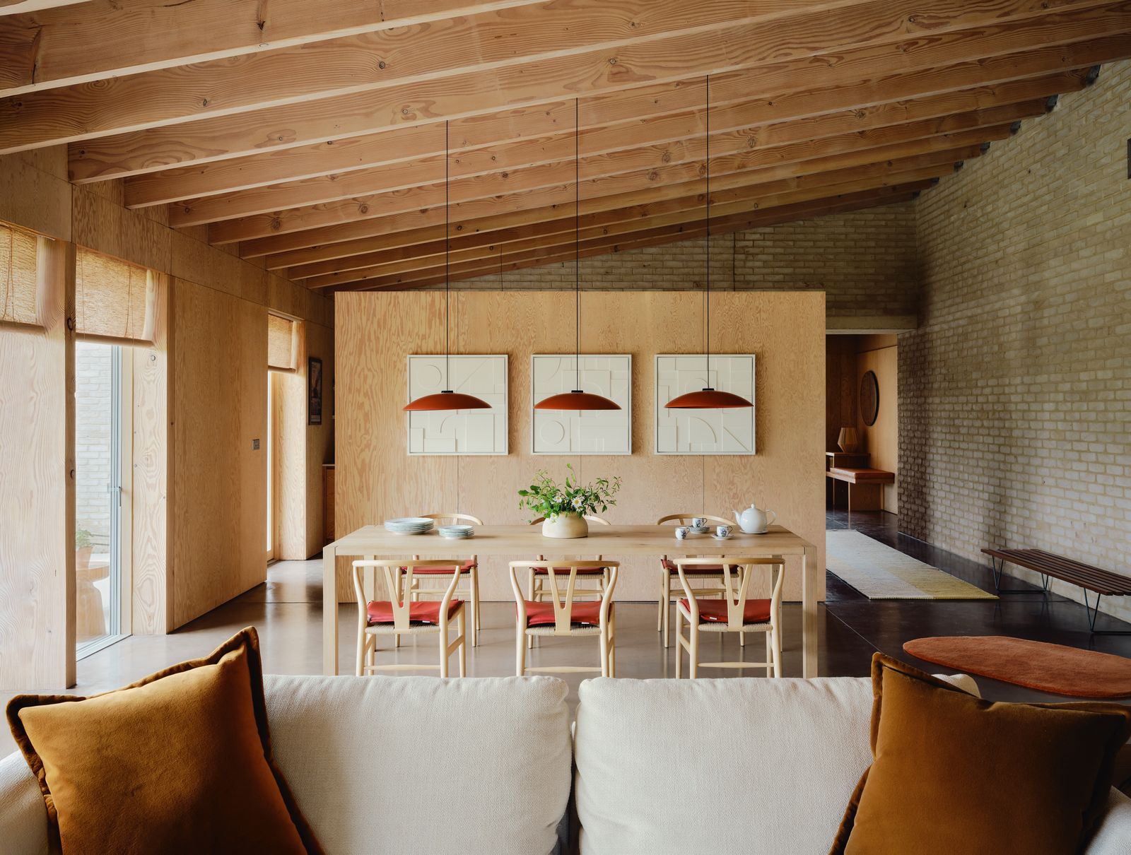 In the dining area Santa amp Coles ‘HeadHat Plate pendant lights in tile red pick up on the leather seat cushions of...