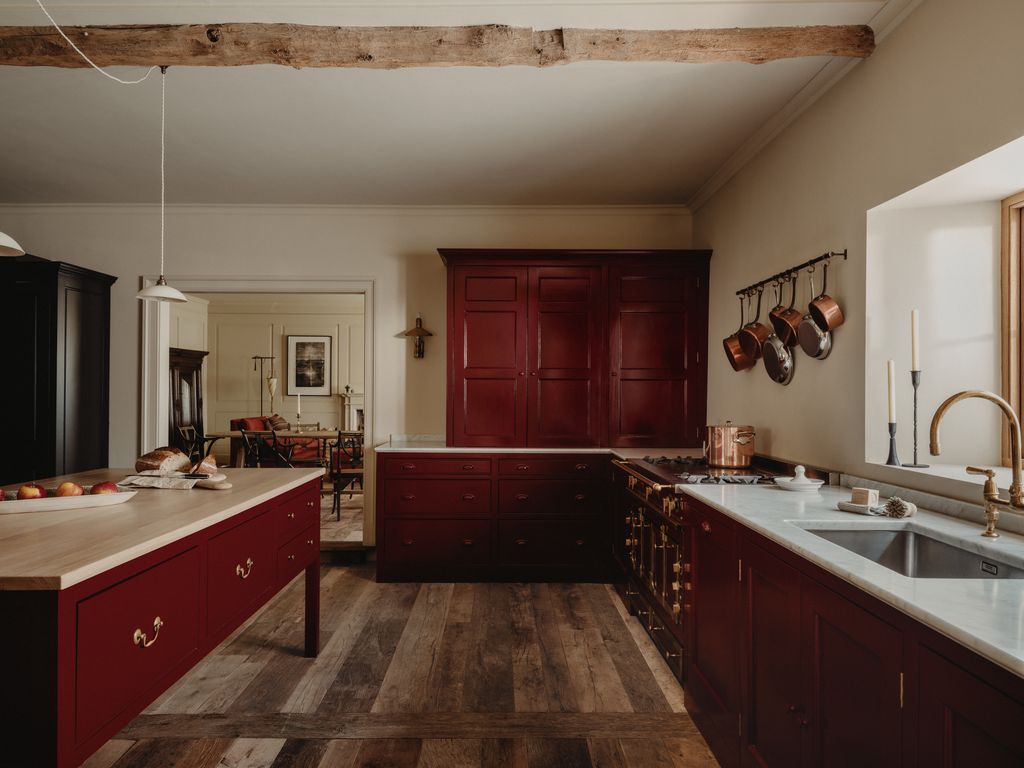 The kitchen cabinets designed by Laura and Gracy and made by a local joiner are handpainted in a custom red burgundy...