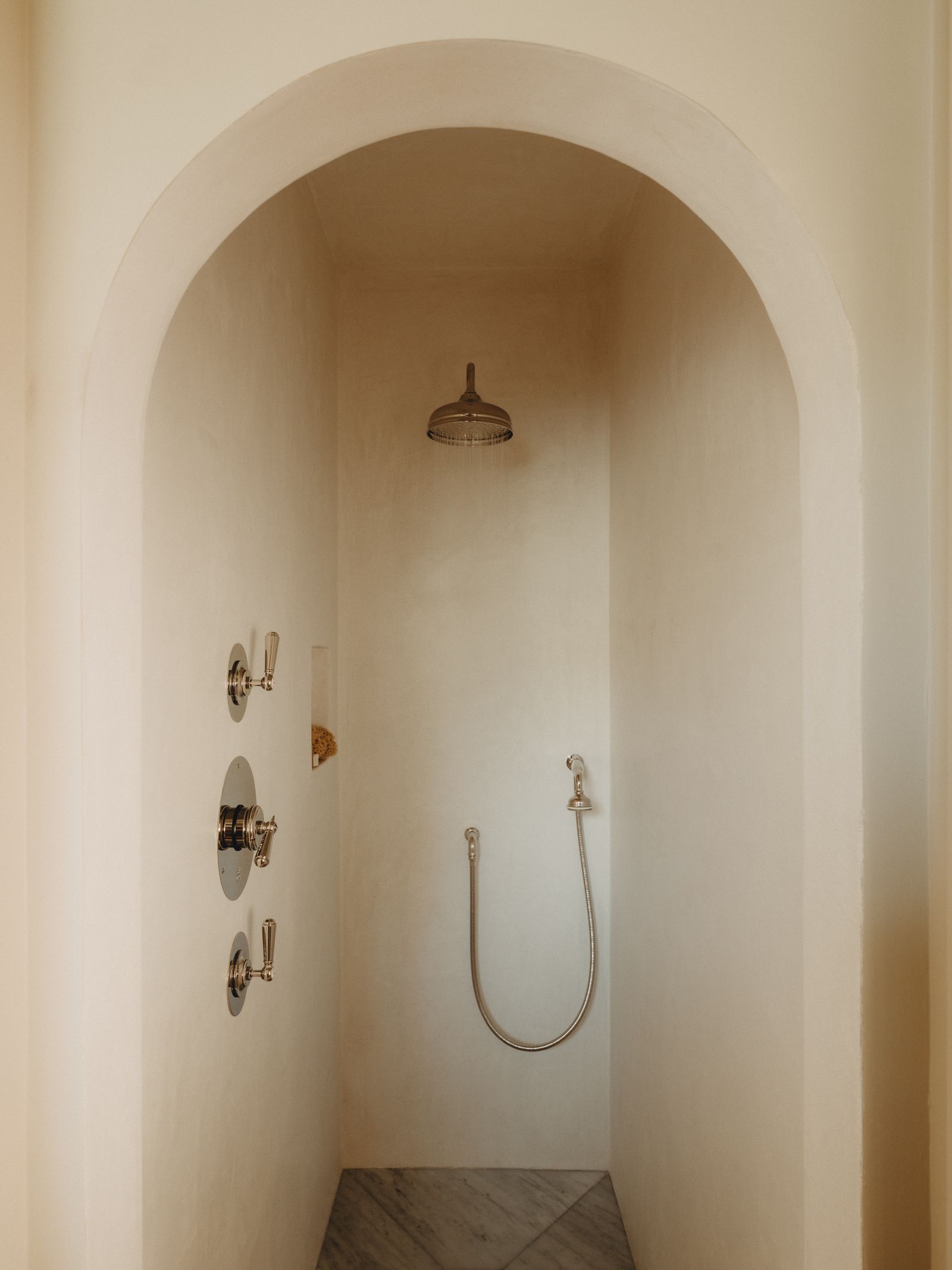 An arched shower recess lined in tadelaket in a Cotswold house by Berkeley Hawkes