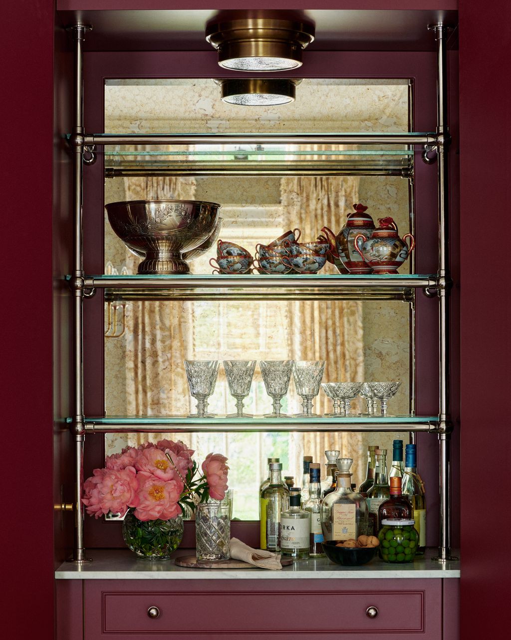 The home bar provides a striking pop of colour with Benjamin Moore's ‘Raisin Torte a rich burgundy. That bar itself has...