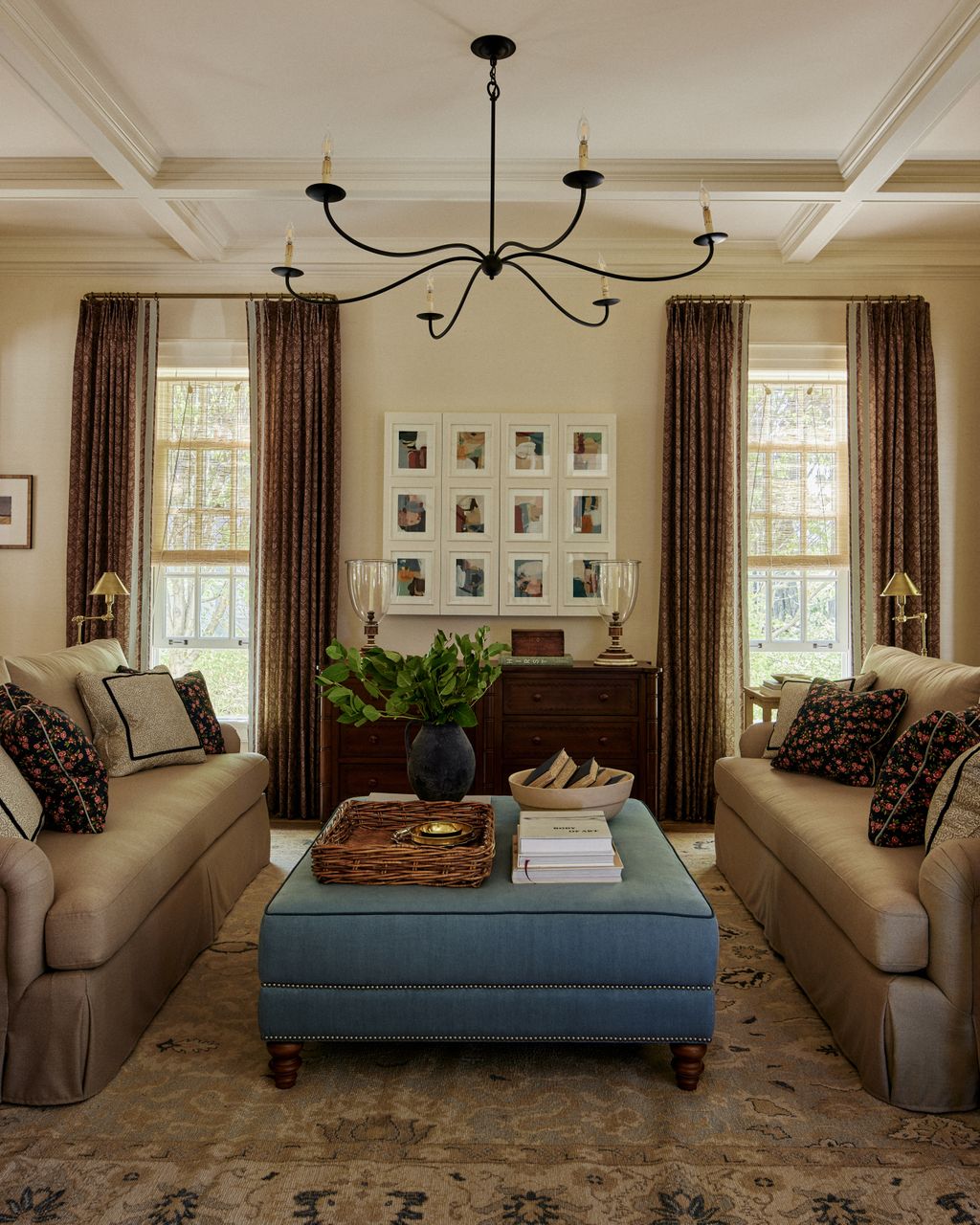 The family room cleverly balances restraint and drama with this wrought iron chandelier by Currey and Company. Rhiannon...