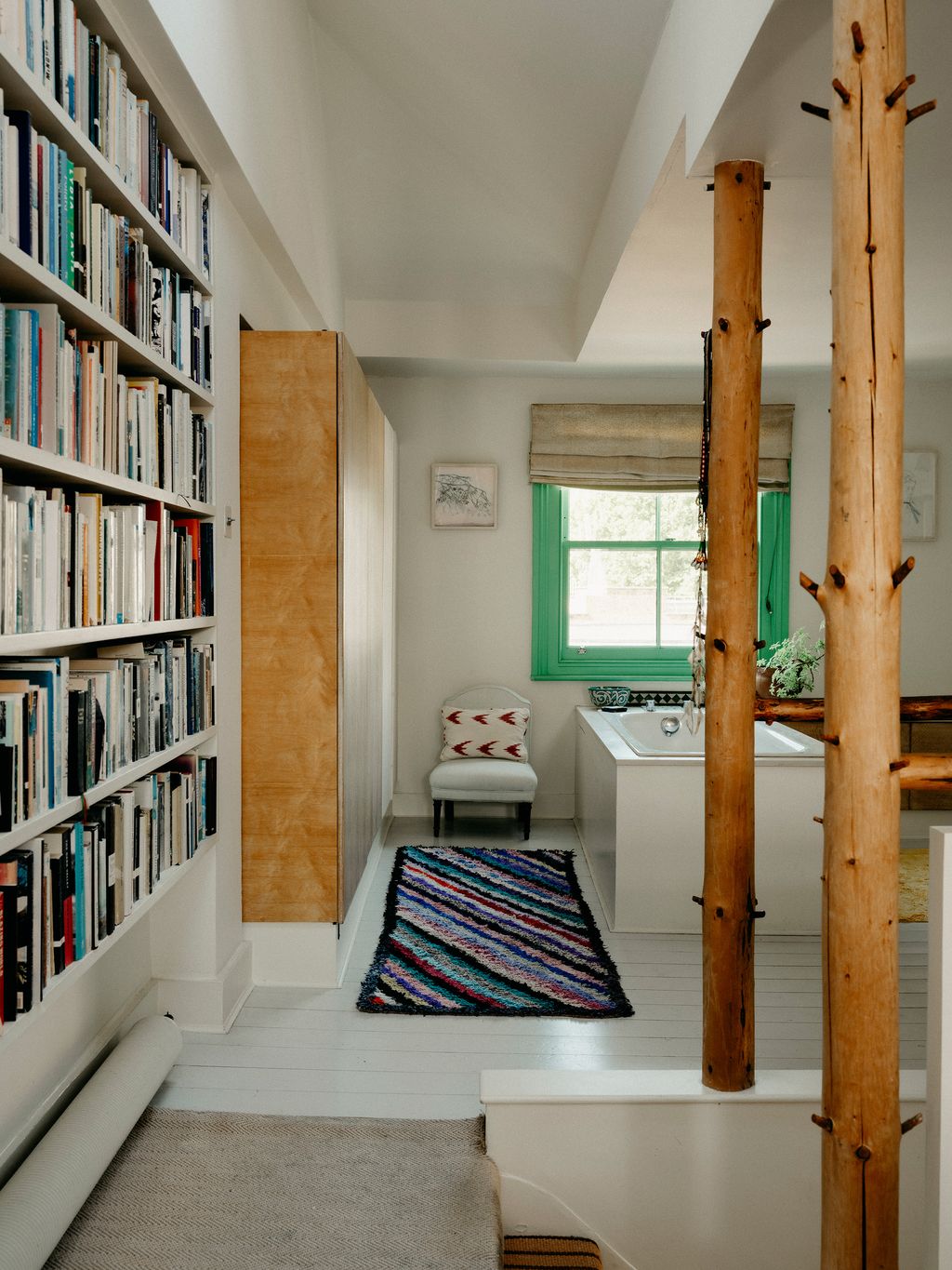 Tarka and Davids top floor open plan bedroom and bathroom is divided by the staircase and wooden poles made from trees...