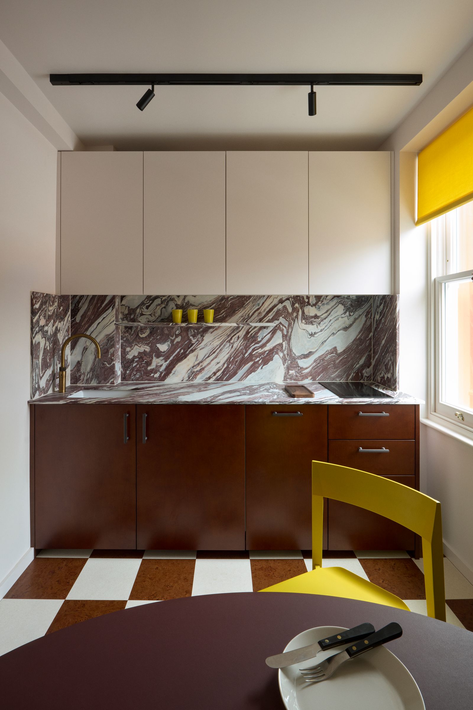 A cheerful yellow blind in a Marianna Kennedy bookcloth plus a NonStandard ‘Geometer chair in the same shade pop against...