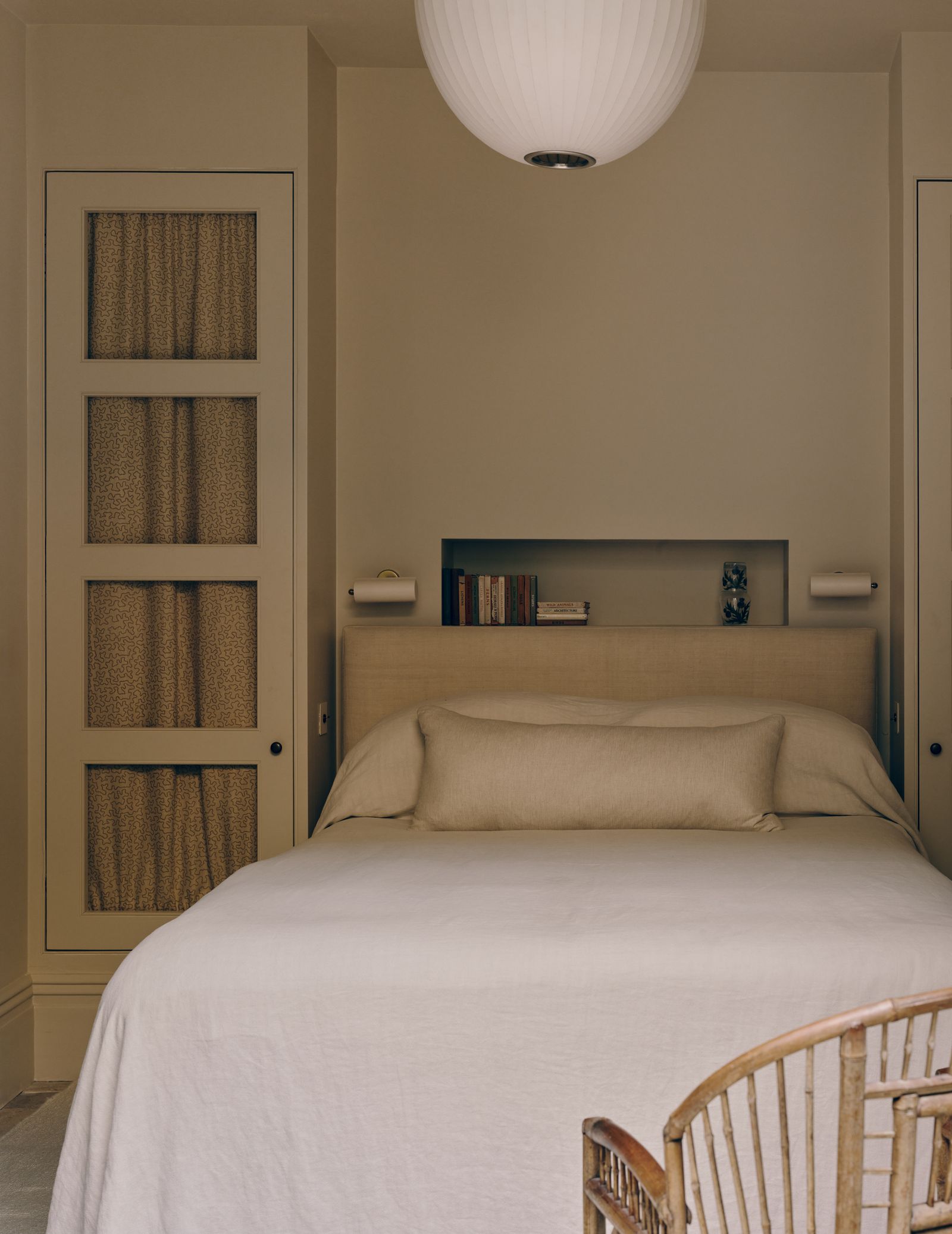 In this spare room of a London house cleverly designed builtin wardrobes form an alcove for the bed.