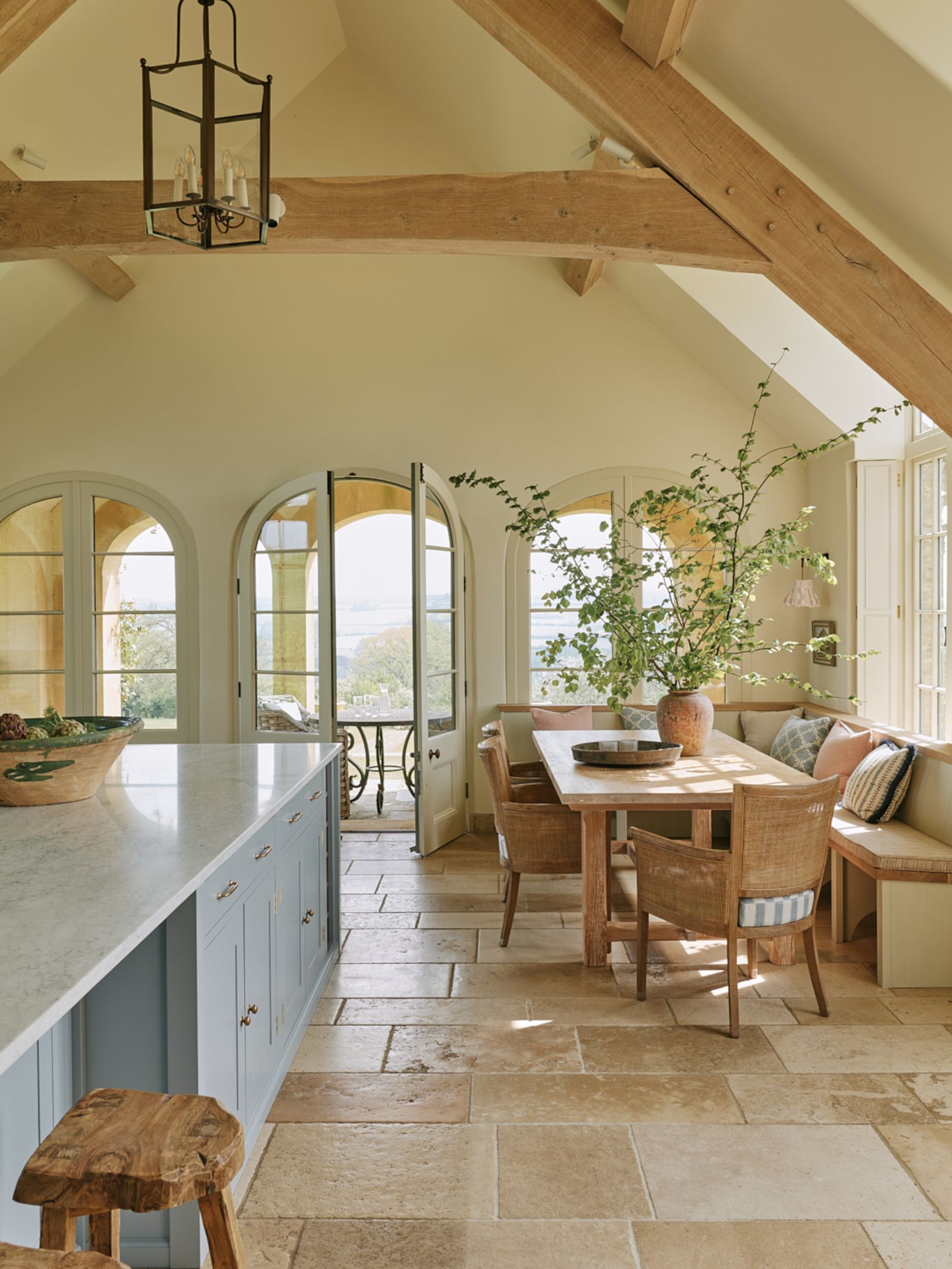 The kitchen opens onto an Italianstyle loggia that offers expansive views over the Warwickshire countryside. Oka dining...
