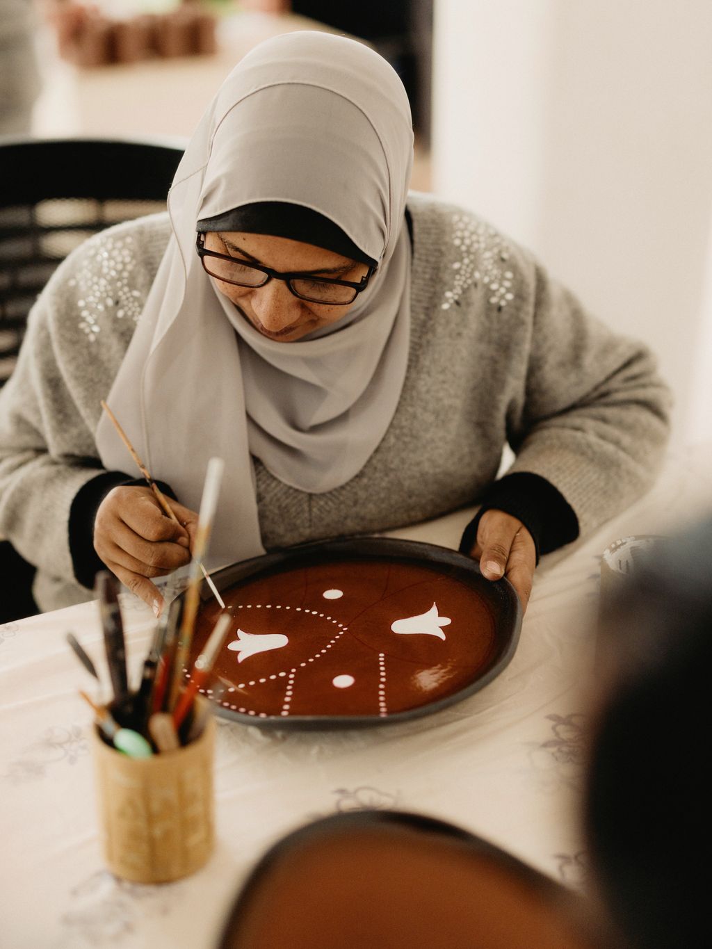 Warda Ali Hassan painting plates.