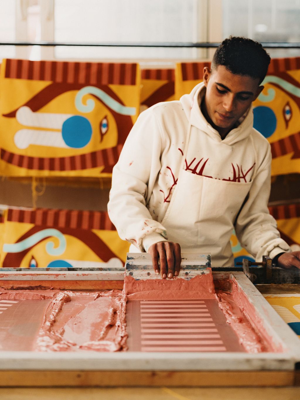 At the Anūt Cairo factory Ahmed Fares screenprinting a design for a beach bag.
