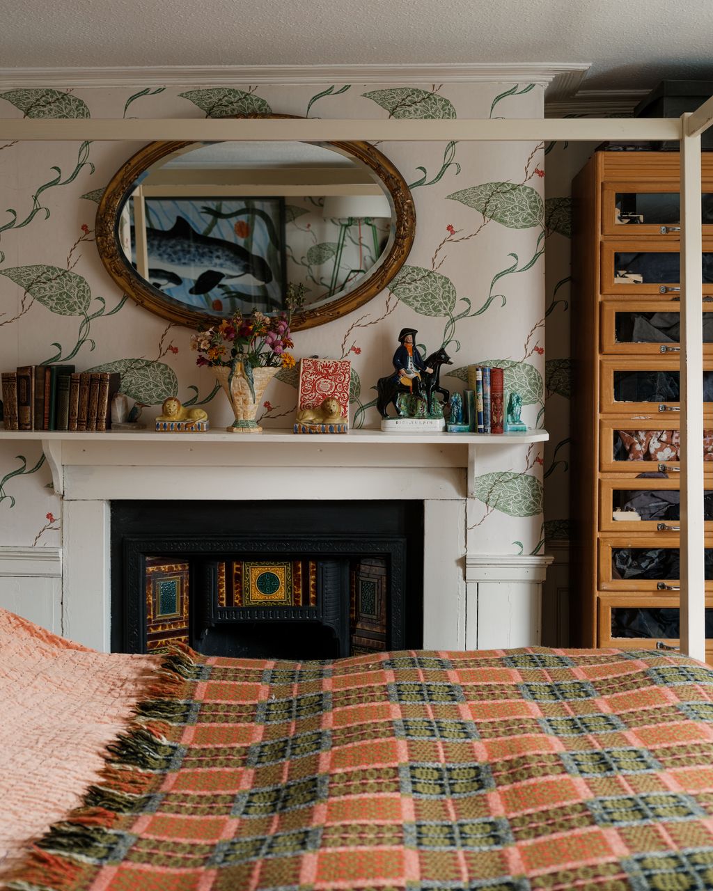 Mick and Brita's bedroom has an original tiled fireplace and wallpaper in Edward Bawden's ‘Seaweed design available...