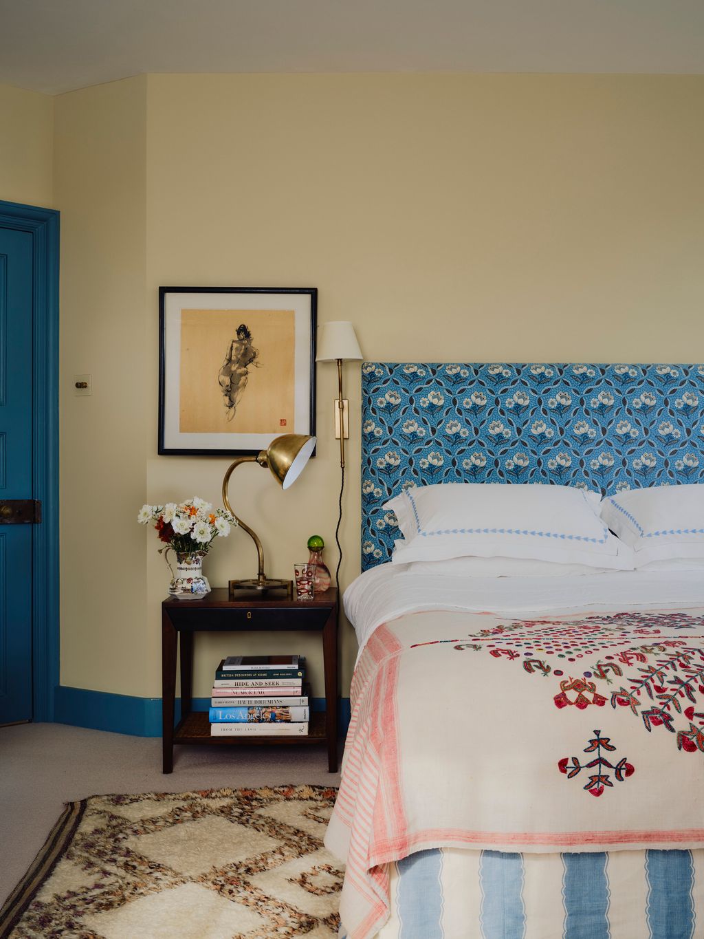 This spare room is a lesson in mixing bold colour and pattern with neutral elements. The headboard is upholstered in Le...