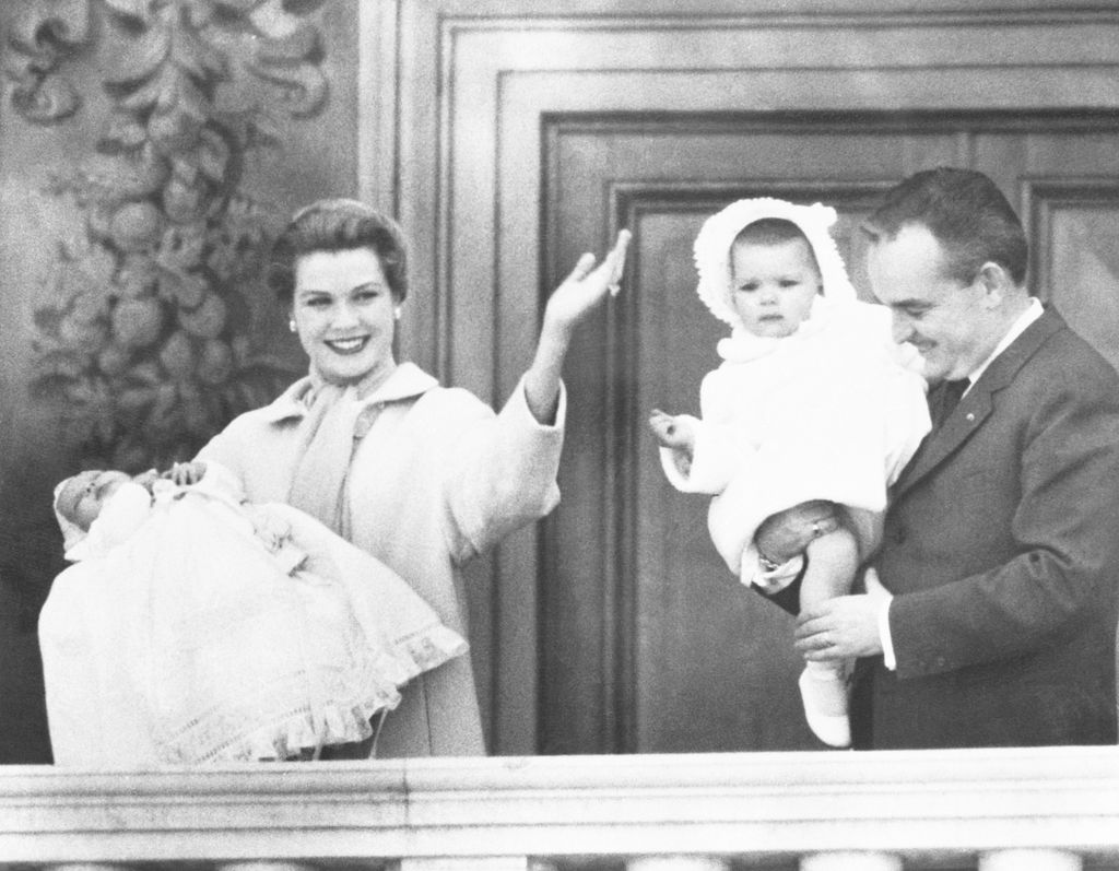 blackandwhite photo of Grace Kelly smiling waving standing in balcony of the Palace of Monaco holding newborn Prince...