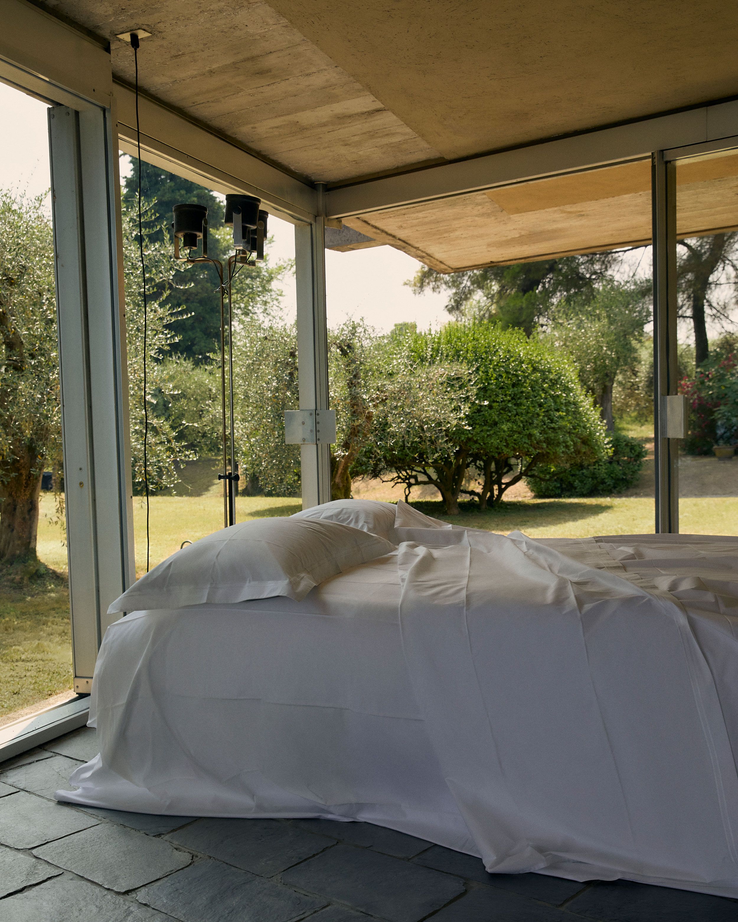 Image may contain: Indoors, Interior Design, Door, Architecture, Building, Housing, Bed, Furniture, Grass, and Plant