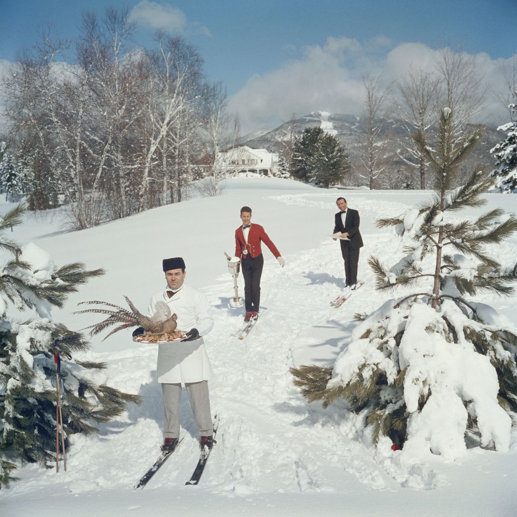 Tre camerieri sugli sci servono gli ospiti su una pista a Stowe Vermont 1962.