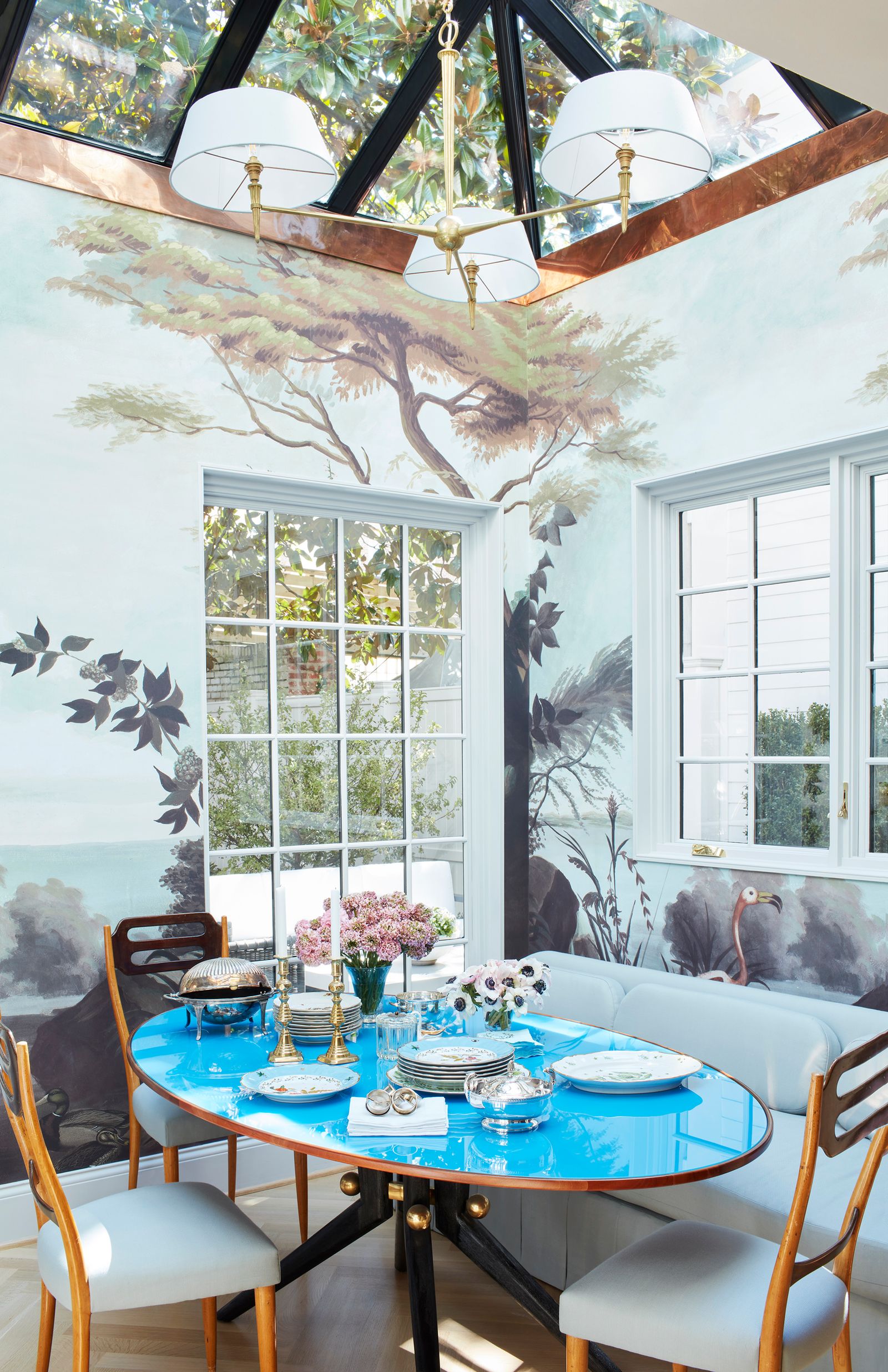 period house in Washington DC  dining room with walls painted in a forest mural vintage Italian dining table with blue...