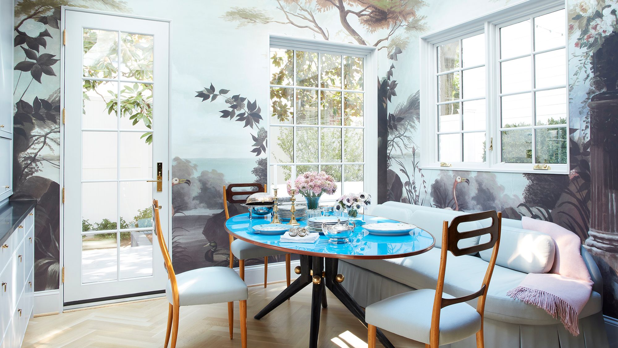 period house in Washington DC  dining room with walls painted in a forest mural vintage Italian dining table with blue...